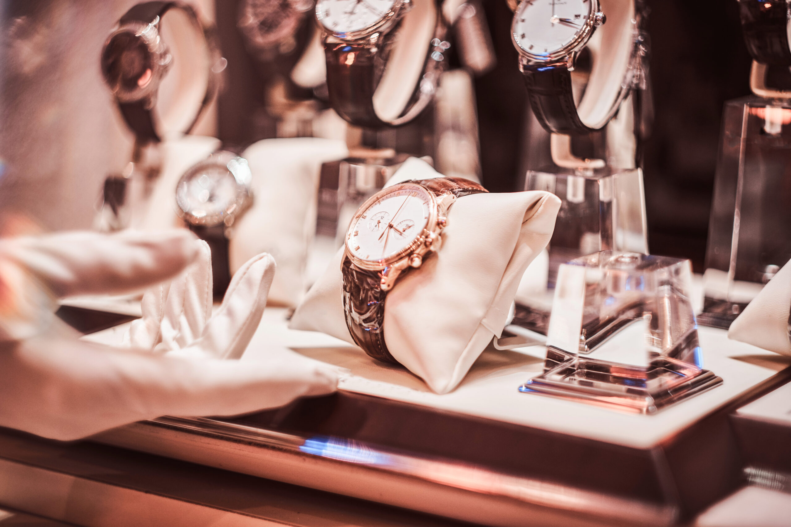 Close-up of the seller's hand in gloves shows the exclusive men's watch from the new collection in the luxury jewelry store